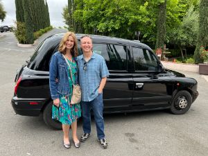 couple standing in front of temecula black car and posing for a picture