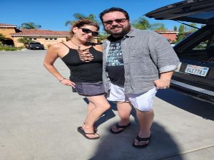 Couple posing outdoors. Woman in tank top, man in gray shirt