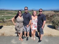 4 people standing together and smiling in a sunny day